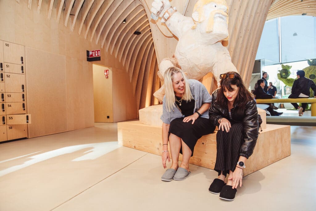 Two women putting on slippers at the Supercell office. 